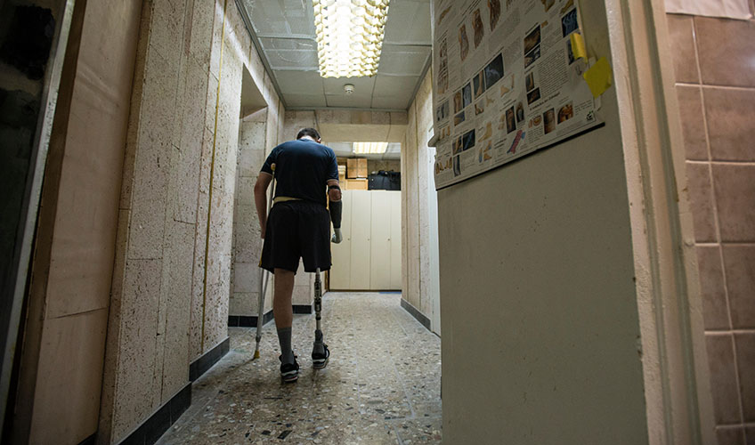 A Ukraine veteran walks down a corridor.