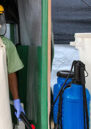 A sprayer wearing protective equipment stands at the entrance of an Ebola treatment unit in Monrovia, Liberia