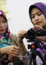 Two women examine the camera during filmmaking workshop