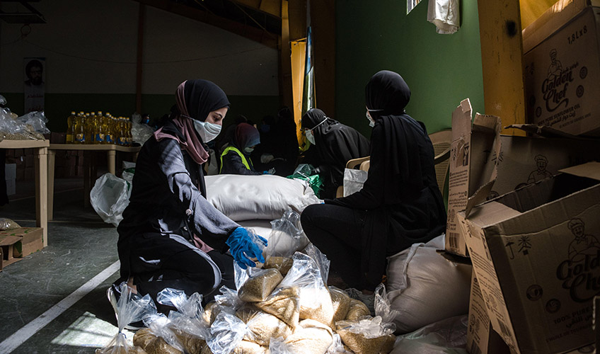 People pack food boxes for Lebanese families, who were already struggling with a financial crisis before the onset of the COVID-19 pandemic