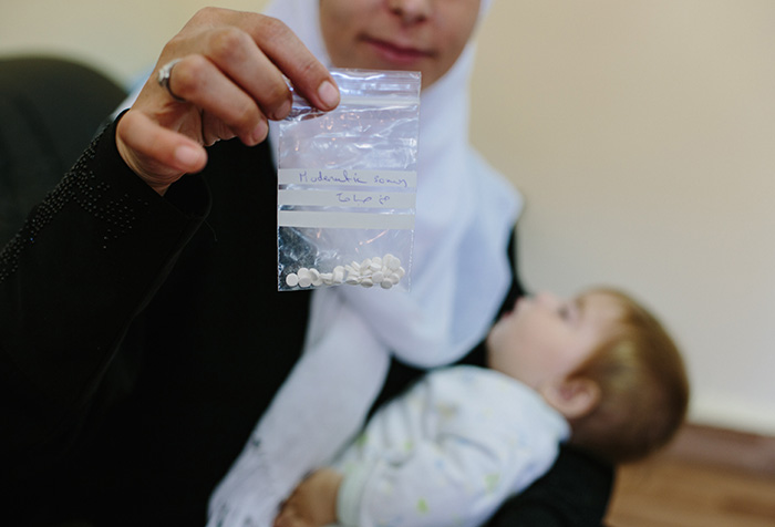 Woman showing medicine to the camera