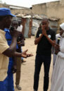 Auwalu and colleagues stand in a group talking as part in a training at Teachers displacement camp