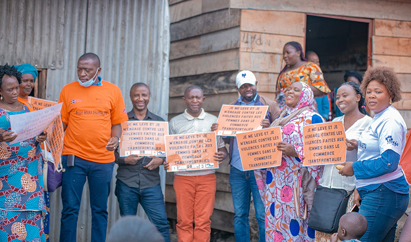 A group of men and women looking signboards calling for an end to violence affecting cross-border traders