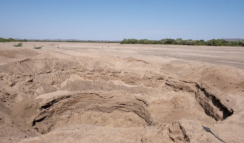 A big shallow well that supplies Kalokol town with water, with the dry river bed in the background.