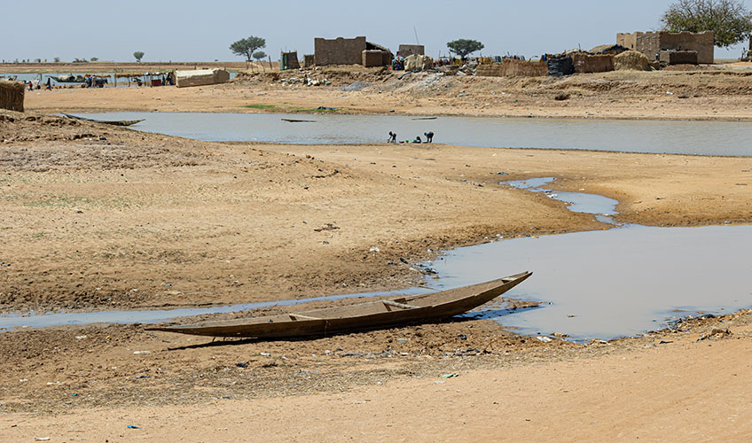 A stranded Pinasse boat in the middle of the dry river. Photo: International Alert. 