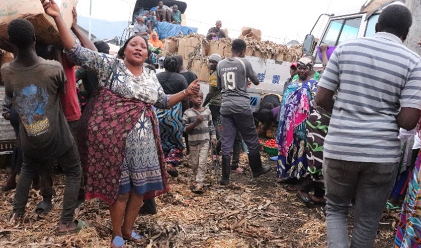 A woman small cross-border trader dances as she sees her tomatoes arriving at the cross-border market of Kahembe, Birere in Goma.