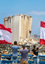 Lebanese wave the Lebanese flag at the scene of massive blast in Beirut