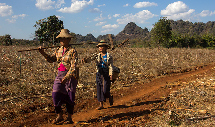 Two women return from managing their crops on the hillside in Kayah state.