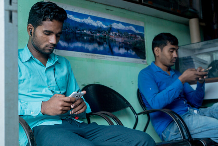 People in Nepal using their smartphones to get updates on the latest news while they wait.