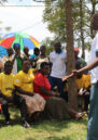 Group of people watching as participants take part in a reconciliation roleplay session in Rwanda