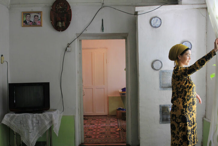 Women looks out the window in Tajikistan