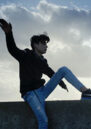Boy in the foreground with his arms out like he is flying