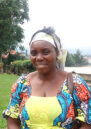 Borauzima wearing a blue and yellow dress with a white headband, smiling at the camera
