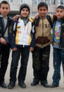 Four boys in Nagorny Karabakh pose in front of a large building.