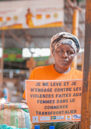 A woman at a stall holds up a sign calling for an end to violence faced by women cross-border traders